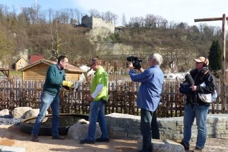Die richtige Pflege von Cortenstahl vor der Kulisse der Burgruine: Volker Kugel und Tobias Nonnenmann (v. li.) mit dem Filmteam des SWR
