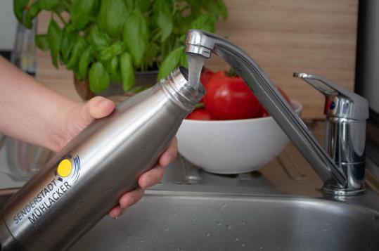 Wasserflasche wird mit Leitungswasser befüllt